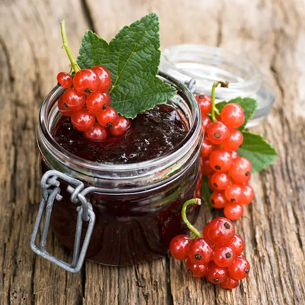 Redcurrant jam on wooden ground