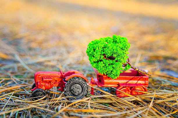 istock Toy Tractor with Miniature Felled Tree in its Bed in the Forest 1757934032