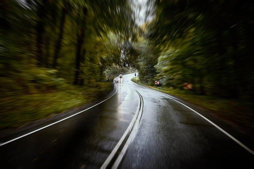 Shiny wet road with dividing line. Overcast and rainy day in October.