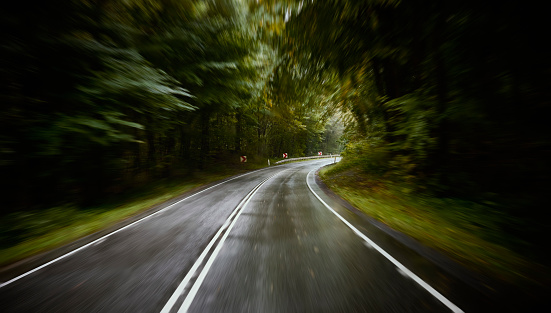 Shiny wet road with dividing line. Overcast and rainy day in October.