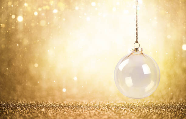Hanging christmas ball ornament surrounded by a dreamy blur of golden bokeh lights, creating a warm and inviting festive atmosphere, creative multiple exposure effect, christmas background
