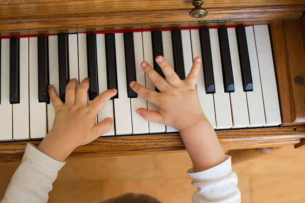 istock Two year old toddler boy playing on piano 175797989