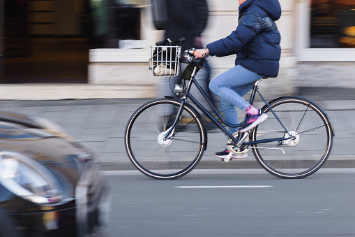 picture of an unrecognizable person with a bicycle on the move in city traffic