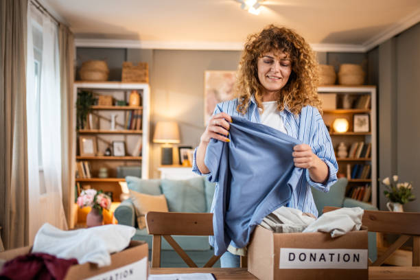 istock A caring young woman packs clothes for donation into a cardboard box 1758003003