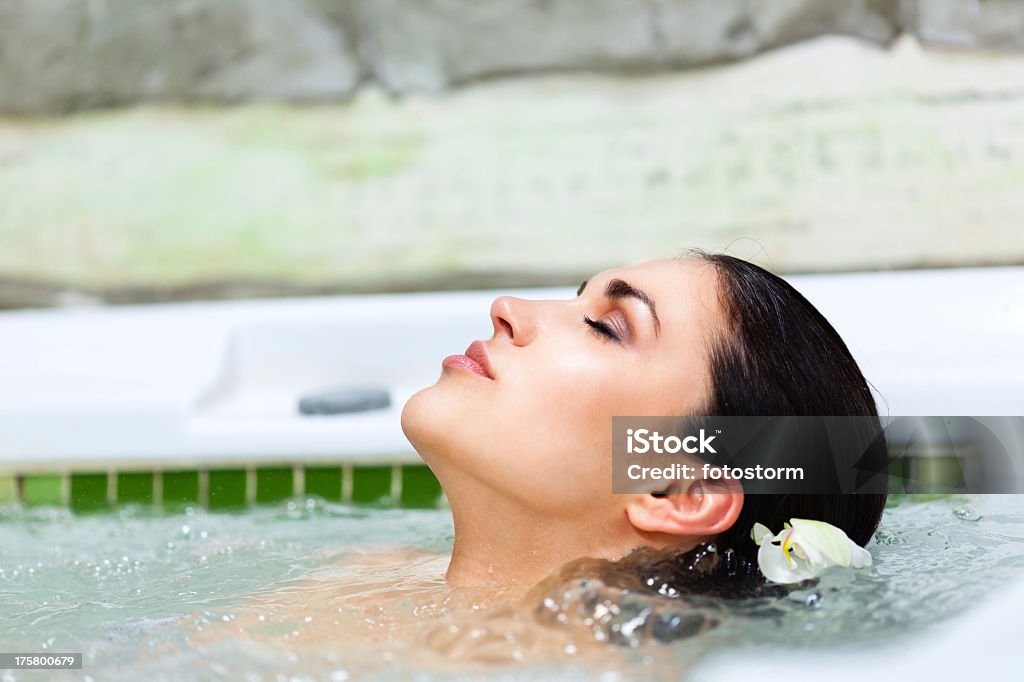 Hermosa mujer relajante en el jacuzzi del spa - Foto de stock de Acogedor libre de derechos