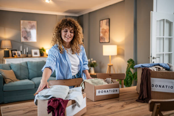 istock A caring young woman packs clothes for donation into a cardboard box 1758013152