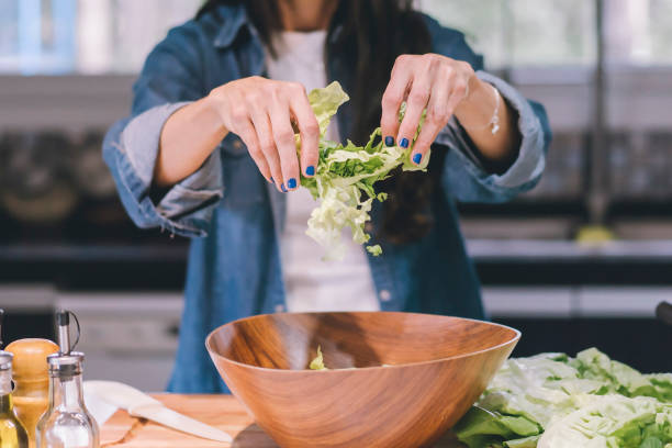 istock A woman preparing a green salad in her kitchen. 1758023035