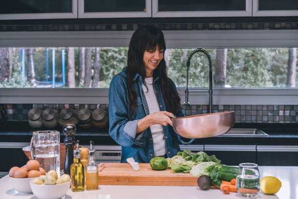 istock A woman cooking vegetables in a copper wok 1758025800