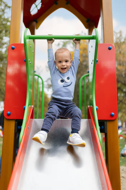 Portrait of cute boy on playground house slide. Childhood concept.