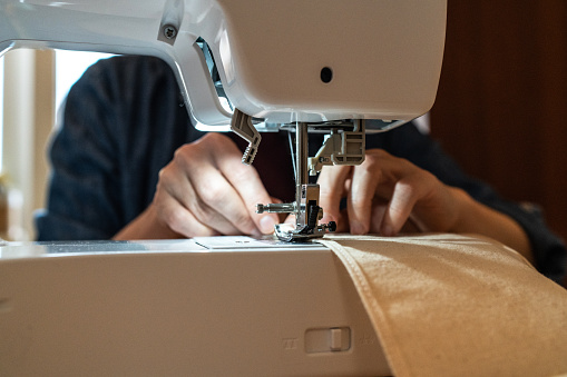 Close up woman working with sewing modern machine