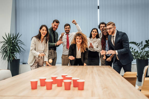Young colleagues playing beer pong