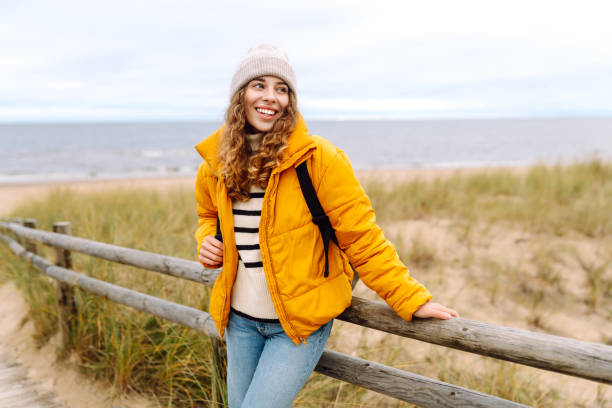 istock A beautiful young tourist woman in a yellow jacket with a backpack. 1758057666