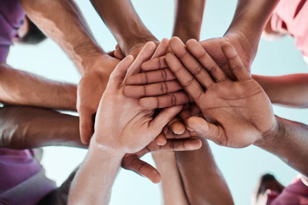istock People, teamwork and hands together in collaboration, goals or community for motivation below. Closeup of group piling in team building, solidarity or trust in support for sports, rugby or match 1758084847