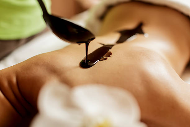 горячий шоколад массаж - massaging chocolate spa treatment body стоковые фото и изображения