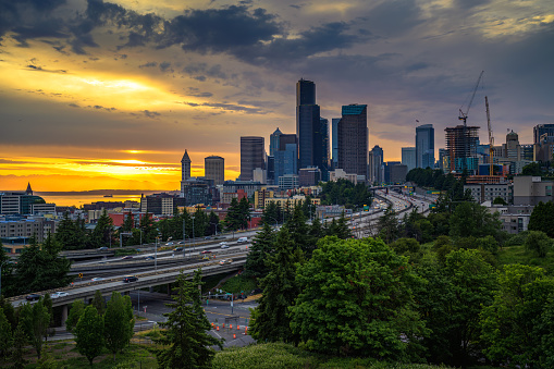 Dramatic sunset over the Seattle downtown skyline, with traffic on the I-5 and I-90 freeway interchange, viewed from Dr. Jose Rizal Bridge.