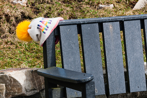 Lost child's woollen hat left on a park bench.