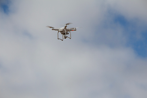 A large drone surveying a field of crops