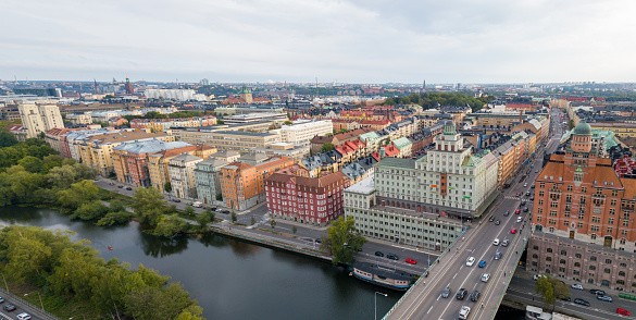 From a drone's panoramic perspective, the serene waters of Karlbergssjön converge with the architectural marvel of Sankt Eriksbron, all set against the expansive backdrop of the Vasastaden urban skyline.