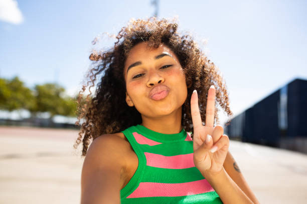 istock young woman taking selfie with peace hand gesture 1758135349