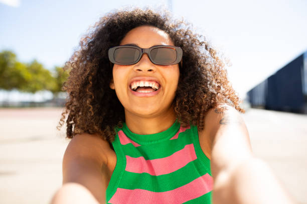 istock happy young woman laughing while taking selfie 1758135380