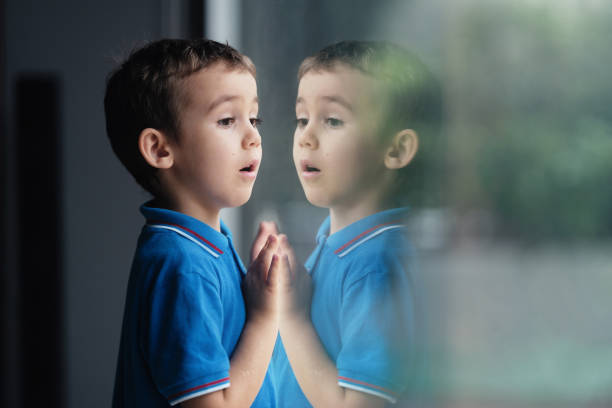 istock Little curious child boy looking out of window 1758144647