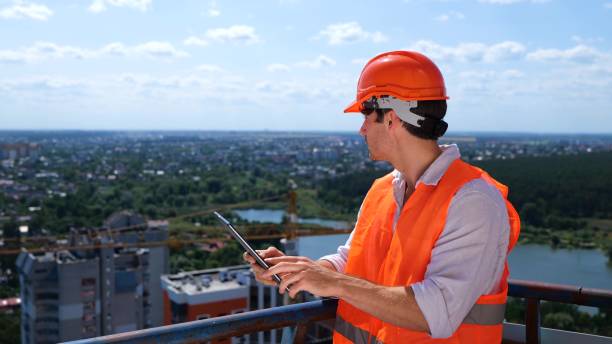 istock Young man in a hardhat holding a digital tablet and looking at the construction site, standing on the roof. Business, building, industry concept. Slow motion 1758162995