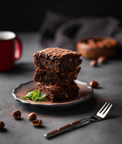 istock A stack of chocolate brownies with mint and  hazelnuts on a dark  background with cup of coffee and nuts. 1758163582