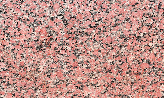 Horizontal or vertical background with natural red granite texture of beige color. Granite texture backdrop. Polished Egyptian red granite slab