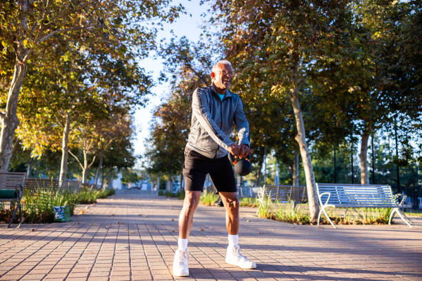 istock Senior black man strength training with kettlebell in the morning light at a park 1758196081