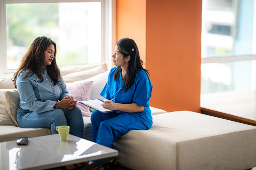 An Asian psychiatrist or professional psychologist conducts counseling or therapy sessions with female patients who are suffering from mental health problems.