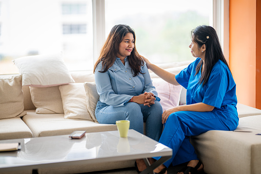 An Asian psychiatrist or professional psychologist conducts counseling or therapy sessions with female patients who are suffering from mental health problems.