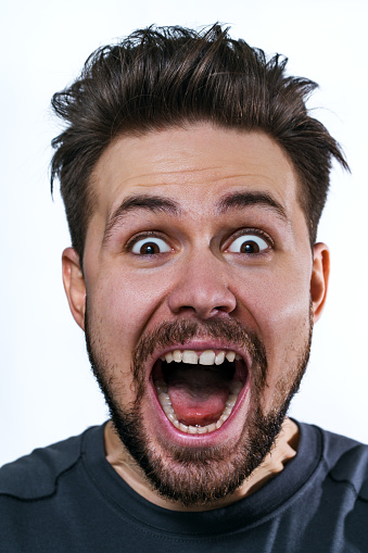 Young crazy man emotional wow portrait on white background