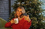 Woman using phone among Christmas atmosphere