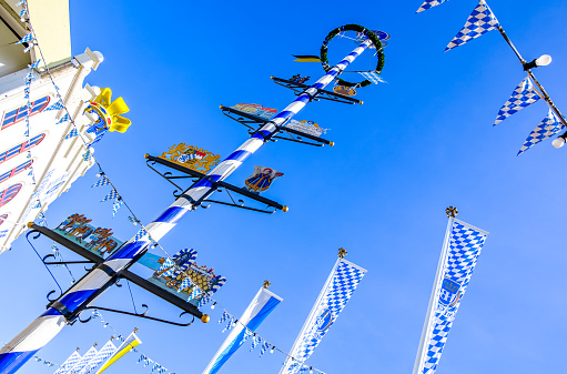 Munich, Germany - September 29: typical wooden bavarian maypole in front of blue sky at the oktoberfest in Munich on September 29, 2023