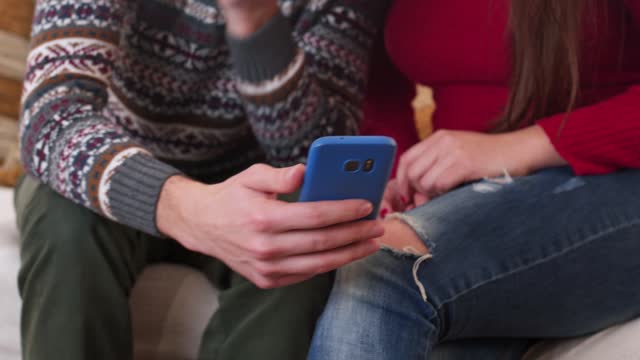 Young Couple Using Smartphone At Home