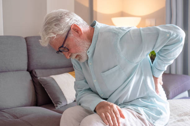 istock Old senior man sitting at home sofa alone suffering for back pain, sciatica, sedentary lifestyle. White haired grandfather touching his back, healthcare concept 1758306870