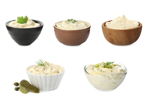 Set of bowls with tartar sauce on white background