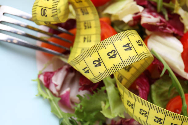 salada saudável com fita métrica em prato azul claro, closeup. conceito de dieta - plate blue loss tape measure - fotografias e filmes do acervo