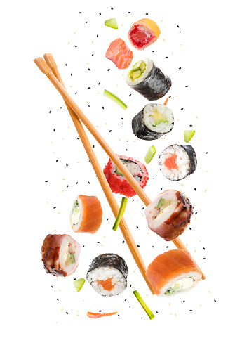 Sushi rolls and wooden chopsticks flying on white background