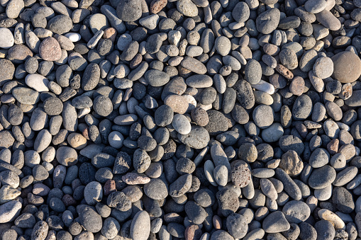 Background of sea stones. Close-up of stones of different shapes and sizes on the beach