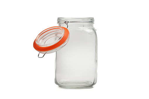 Empty glass jar for bulk products with an open lid on a white background. Copy space.