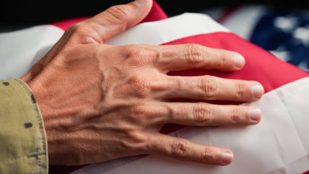 istock Hand of a solider touching USA flag 1758339349