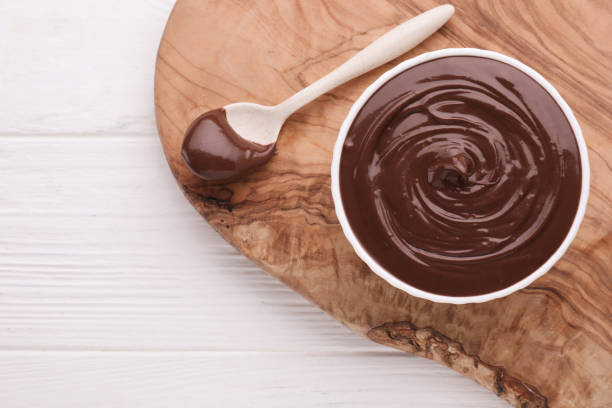 istock Bowl with tasty chocolate paste and spoon on white wooden table, flat lay. Space for text 1758341604