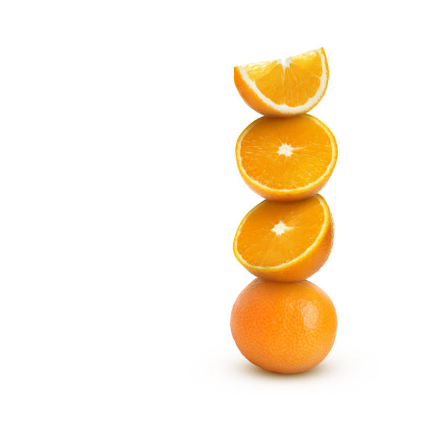 Stacked cut and whole oranges on white background
