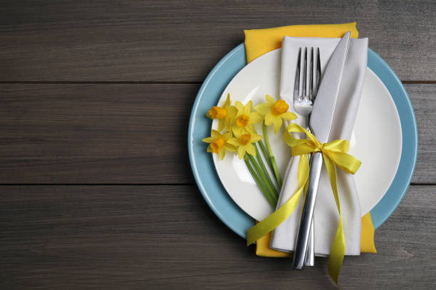 istock Festive table setting with narcissuses and cutlery on wooden table, top view with space for text. Easter celebration 1758344424
