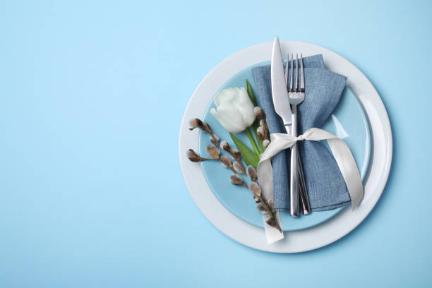 istock Festive table setting with willow twigs and tulip on light blue background, top view with space for text. Easter celebration 1758344904