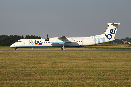 Hoofddorp, Netherlands - August 26, 2013: British flybe Bombardier DHC-8-400 Dash 8 with registration G-ECOT rolling on taxiway V of Amsterdam Airport Schiphol.