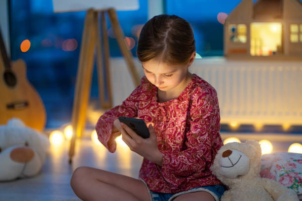 istock Little girl using phone at night 1758354831