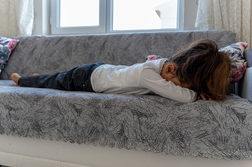 A girl lying on the couch. Girl asleep on the couch. Portrait of a girl child.