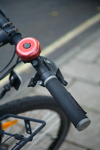 Close-up of a red bell of a bicycle on the street